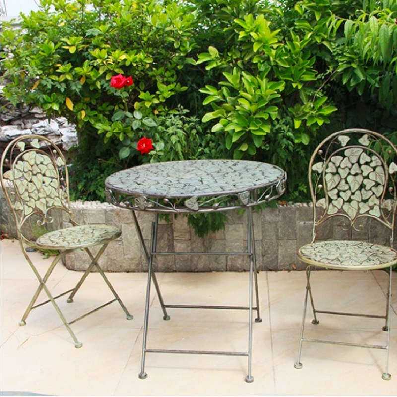 Outdoor Furniture Europe - Retro-Eisentisch und Stühle im alten Innenhof,